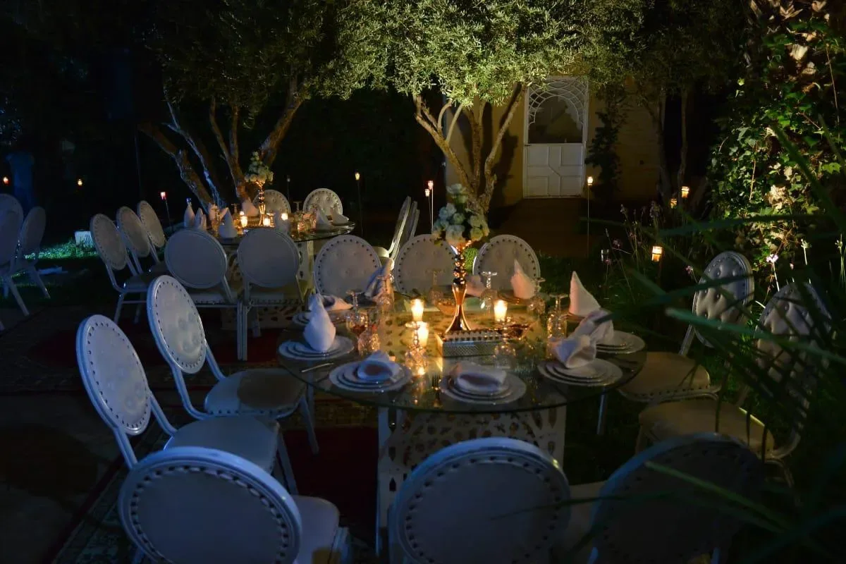 Table ronde dressée en plein air sous les arbres à la bougie, Quattrocento Palace, villa avec piscine à Marrakech