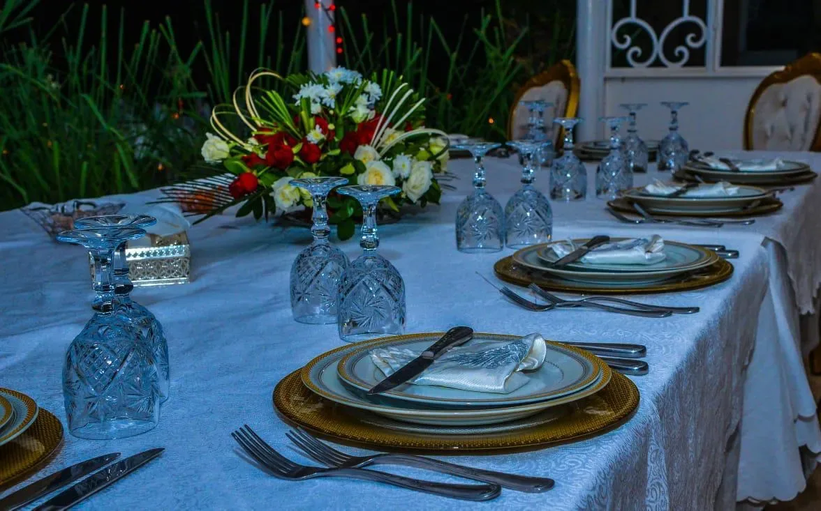 Table dressée en soirée avec verres en cristal et fleurs, villa avec piscine à Marrakech Quattrocento Palace