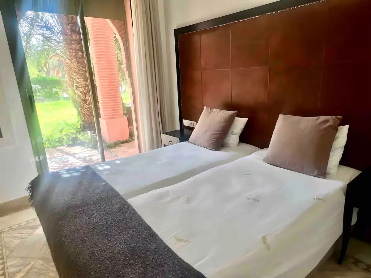 Second bright double bedroom with large glass door facing the garden in an apartment with pool in Marrakech