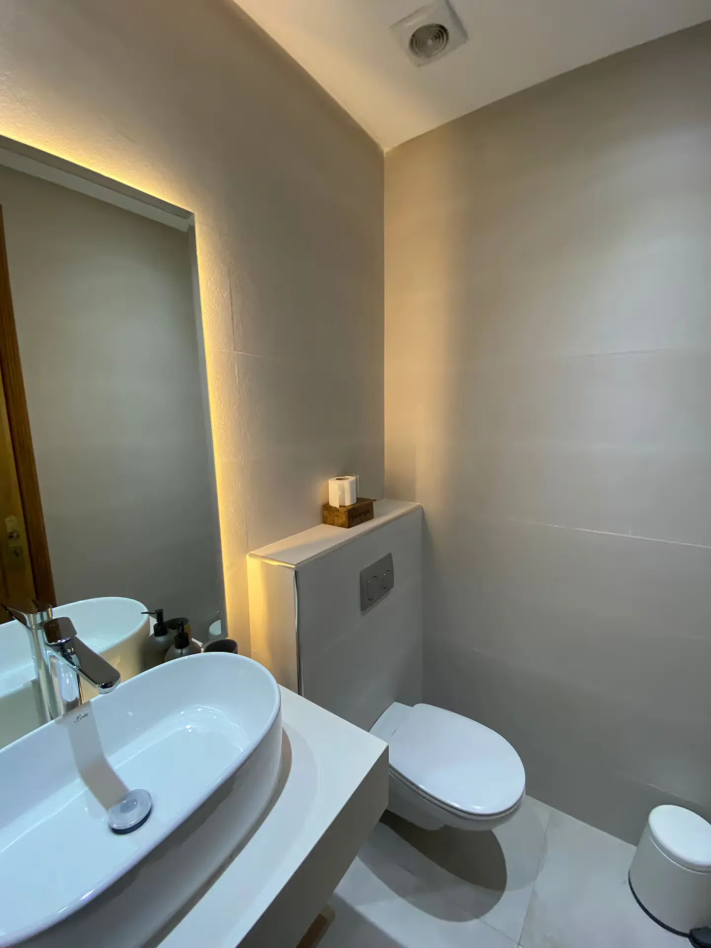 Modern guest bathroom with wall-hung toilet and vessel sink in an apartment with pool in Marrakech
